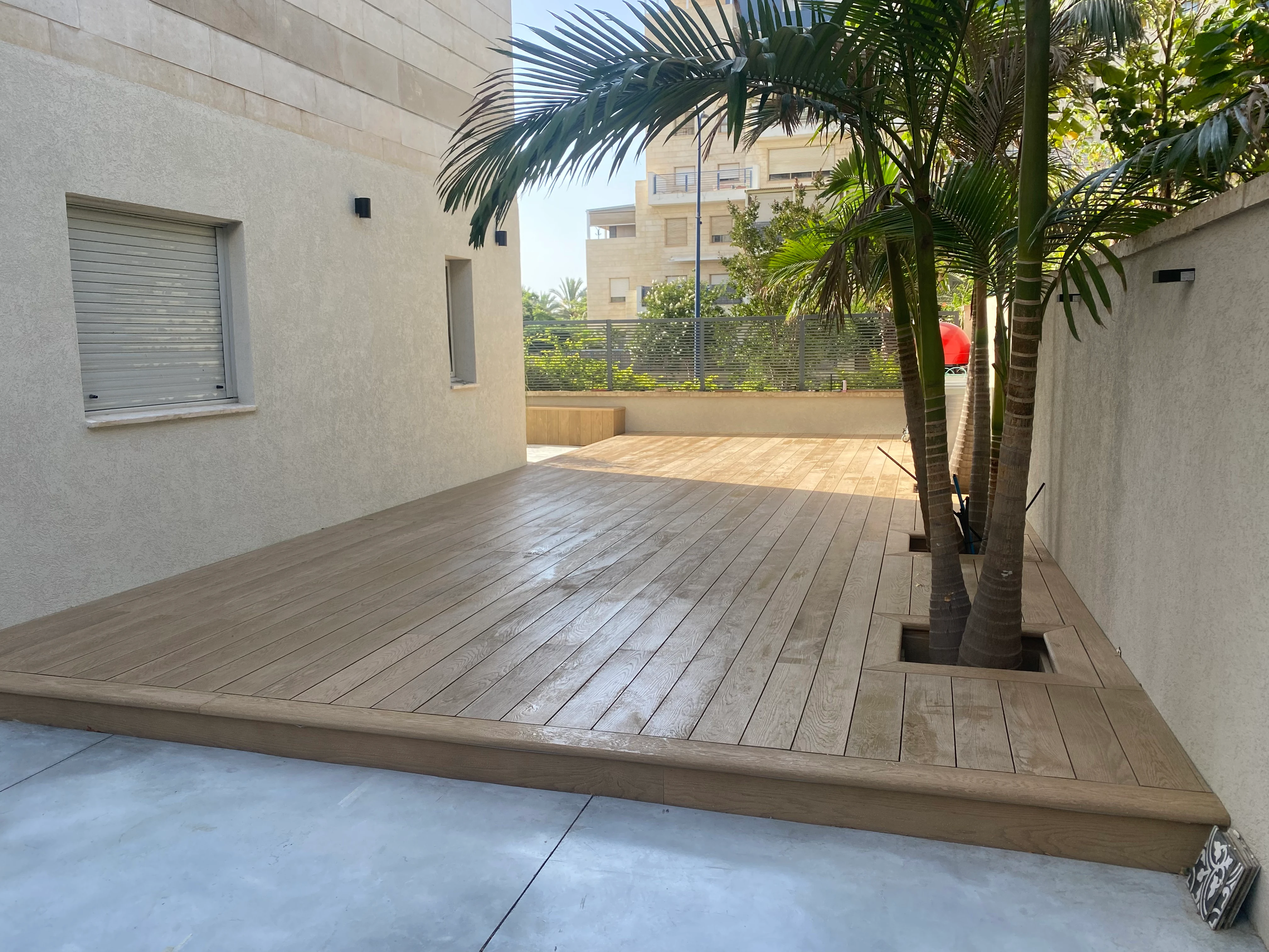 דק Millboard בגוון Golden Oak בחצר ברחובות, לצד עצי הדקל